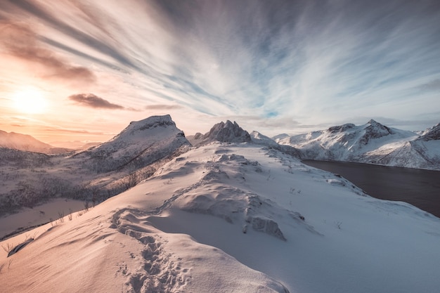 Landscape of colorful snowy hill with footprint at sunrise