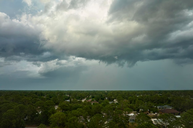 Landscape of dark ominous clouds forming on stormy sky before heavy thunderstorm over rural town area