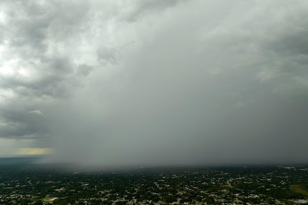 Landscape of dark ominous clouds forming on stormy sky during heavy thunderstorm over rural town area