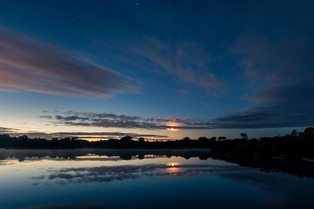 Landscape at dawn with moon between clouds in Los Barruecos