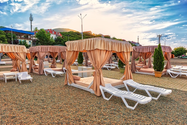 Landscape of a deserted rocky beach in a resort town with shady gazebos