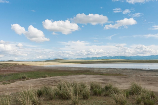 Landscape grass in the steppe Tyva The road near the lake DusKhol Clouds on the horizon