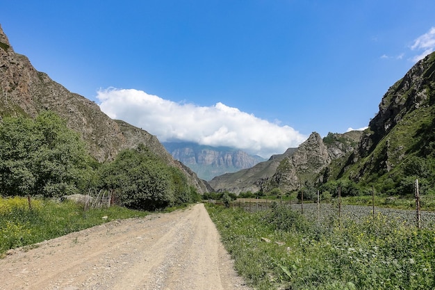 The landscape of the green Aktoprak pass in the Caucasus the road and the mountains under gray clouds KabardinoBalkaria Russia