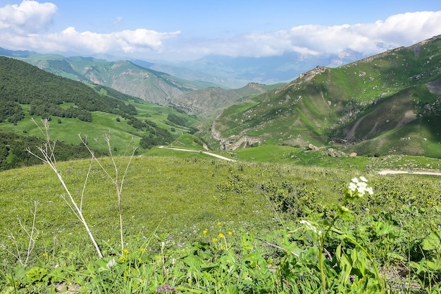 The landscape of the green Aktoprak pass in the Caucasus the road and the mountains under gray clouds KabardinoBalkaria Russia