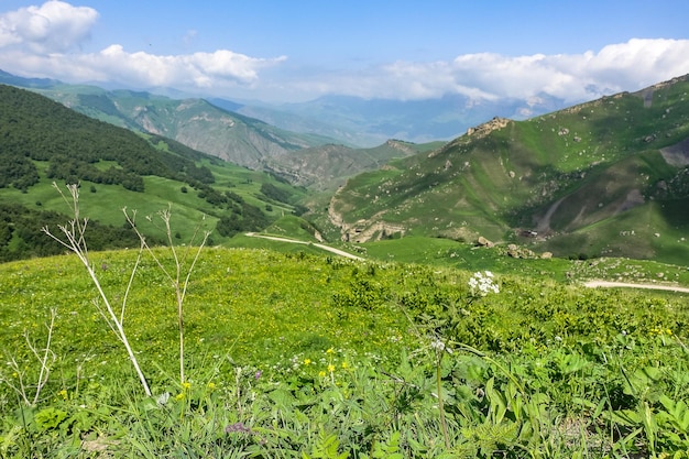 The landscape of the green Aktoprak pass in the Caucasus the road and the mountains under gray clouds KabardinoBalkaria Russia