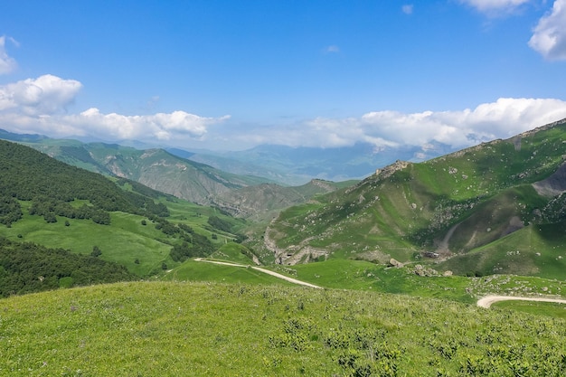 The landscape of the green Aktoprak pass in the Caucasus the road and the mountains under gray clouds KabardinoBalkaria Russia