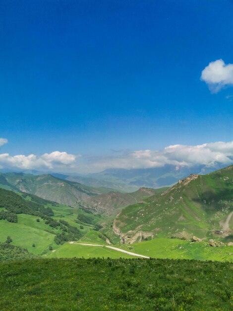 The landscape of the green Aktoprak pass in the Caucasus the road and the mountains under gray clouds Russia