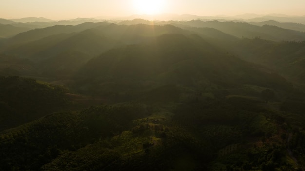 Landscape of mountains layer and forests The sun rays are shining through the fog The play of light and shadows dramatic natural scenery north of thailand aerial view