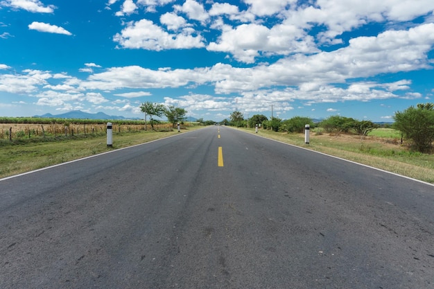 Landscape photo of a paved road with blue sky