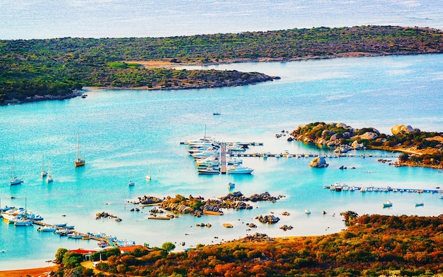 Landscape and scenery of Golfo Aranci at Costa Smeralda, Sardegna island in Italy in summer. Sassari province near Olbia and Cagliari. In Mediteranean sea. Yachts, boats and ships. Mixed media.