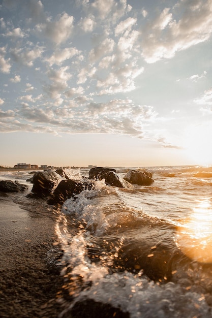 Landscape of the sea at dawn waves and splashes of water in the sun