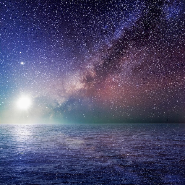 Landscape of sea with moon bright and milky way galaxy in starry night