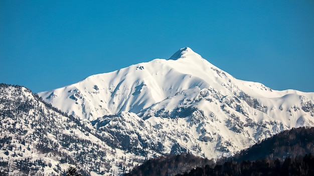 Landscape of the snow mountain with blue sky at Japan Alps Mountain.