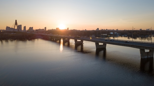 Landscape and sunset with suspension north Bridge across the Dnieper river, Obolon district in Kiev, Ukraine. Photo from the drone