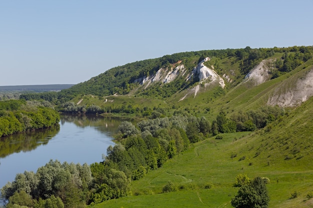 Landscape in the valley of the Don River in central Russia. Top view of the spring coastal forest and pond.