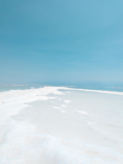 Landscape view on Dead Sea salt crystals formations clear cyan green water at Ein Bokek beach Israel