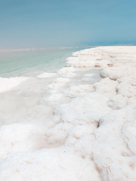 Landscape view on Dead Sea salt crystals formations clear cyan green water at Ein Bokek beach Israel