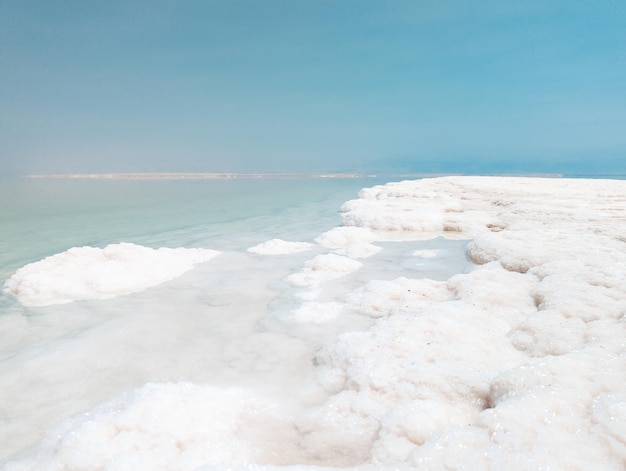 Landscape view on Dead Sea salt crystals formations clear cyan green water at Ein Bokek beach Israel