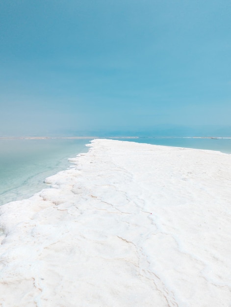 Landscape view on Dead Sea salt crystals formations clear cyan green water at Ein Bokek beach Israel