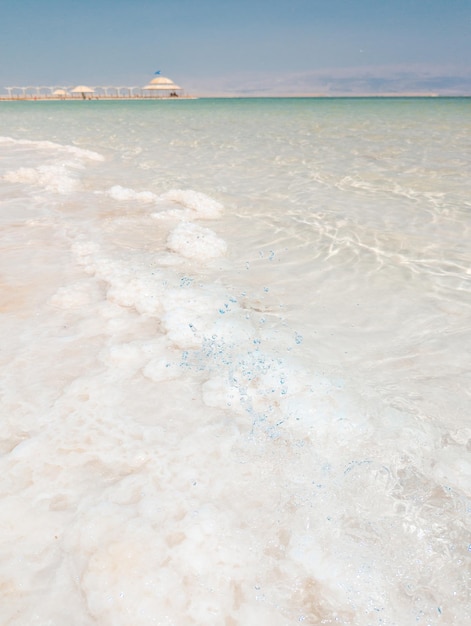 Landscape view on Dead Sea salt crystals formations clear cyan green water at Ein Bokek beach Israel