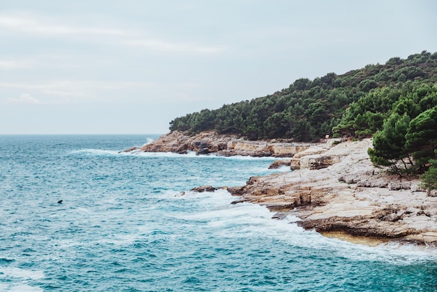 Landscape view of stormy sea water with rocky beach