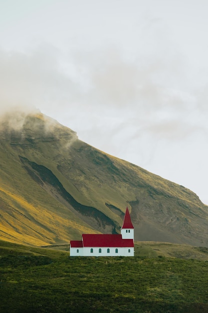 Landscape wallpaper of the Church of Vik i Myrdal in Iceland in front of a massive mountain during the sunset Copy space image moody style Visit Iceland travel route on wastelands