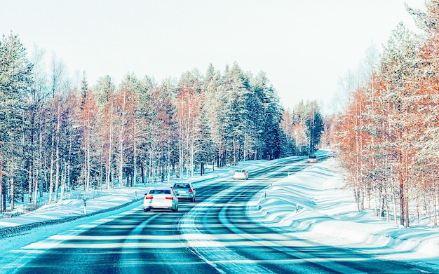 Landscape with Car in snow road in Finland. Vacation trip on highway with nature. Scenery with Winter drive on Holiday journey for recreation. Motion ride in Europe. Transport on driveway.