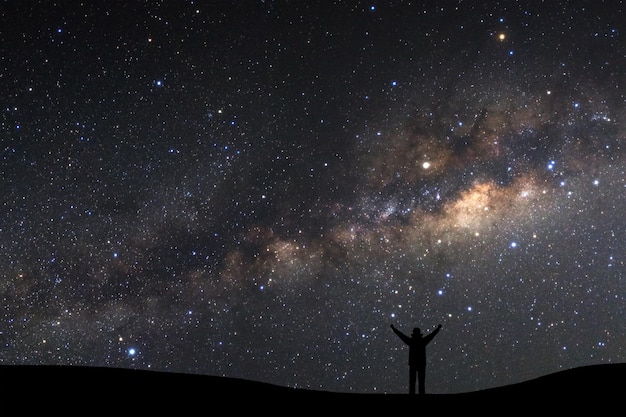 Landscape with milky way Night sky with stars and silhouette of a standing sporty man