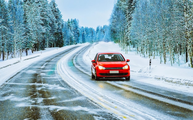 Landscape with red Car in snow road in Finland. Vacation trip on highway with nature. Scenery with Winter drive on Holiday journey for recreation. Motion ride in Europe. Transport on driveway.