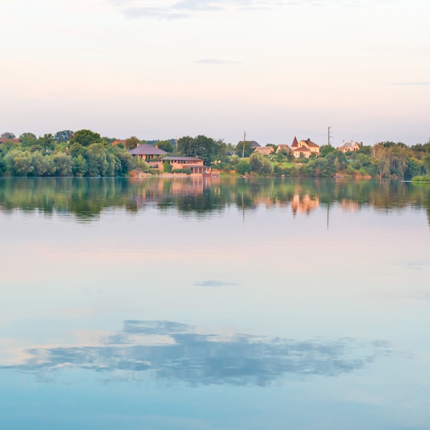 Landscape with sunset on lake, blue water and colorful sky