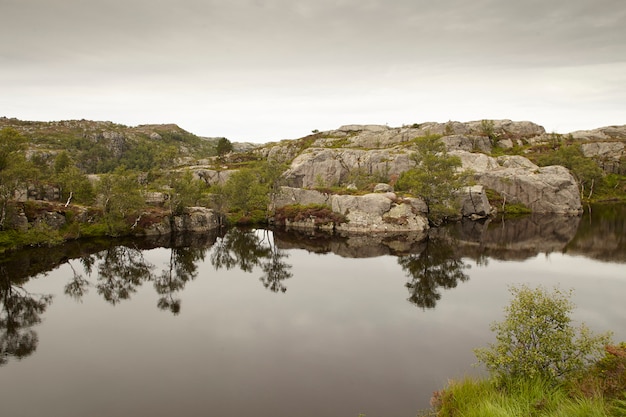 Landscape with water reflection, trees and rocks