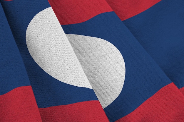 Laos flag with big folds waving close up under the studio light indoors The official symbols and colors in banner