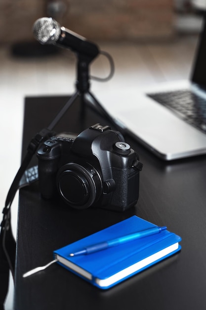 Laptop camera microphone and notebook on a journalist's work desk