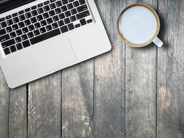 Laptop cappuccino on wooden board top angle view. work energy concept