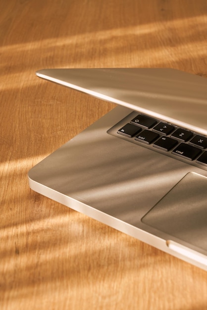 Laptop closeup on a wooden table with daylight.