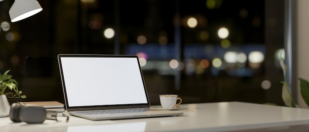 Photo a laptop computer and accessories on a table against the window with a night city view