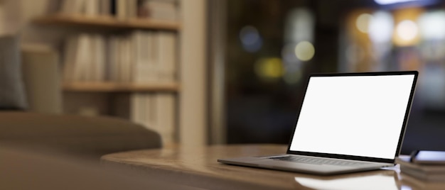 A laptop computer mockup on a coffee table in a contemporary living room