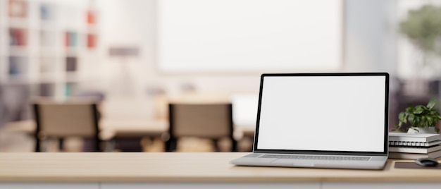 A laptop computer mockup on a table with a blurred background of a contemporary meeting room