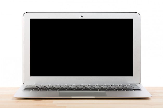 Laptop computer with blank black screen on light wooden table. Isolated.