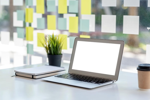 Laptop computer with blank white screen on table mock up