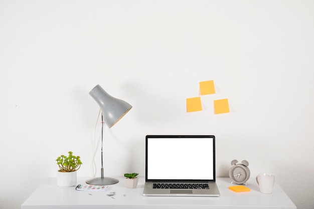 Laptop on desk near decorations and sticky notes