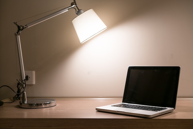 Laptop on a desk with lamp