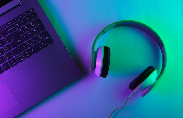 Laptop and headphones with neon green and purple light