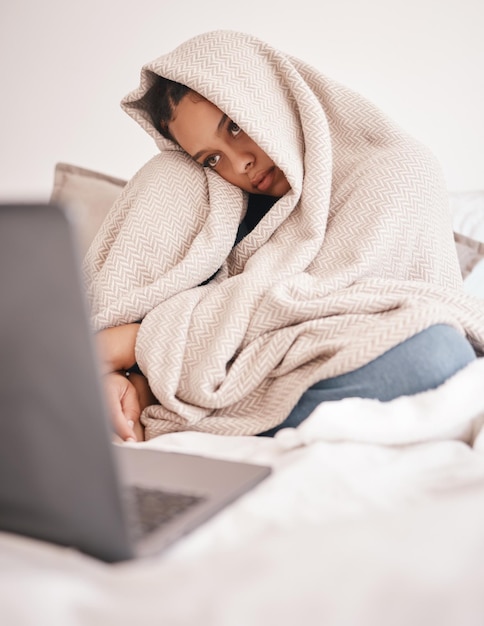 Laptop mental health problem and insomnia woman from Rome feeling sad on a bed with depression Depressed person with a computer in a house bedroom blanket with stress sick or with anxiety at home