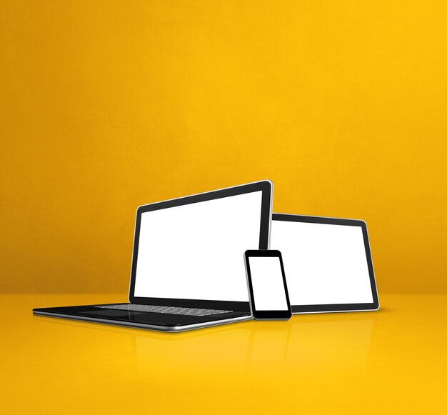 Laptop, mobile phone and digital tablet pc on yellow office desk.