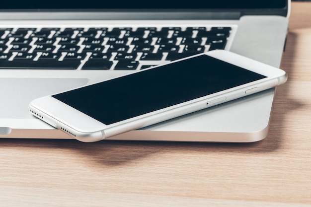 Laptop and mobile phone on the table. Workspace .