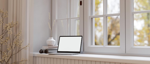 Laptop mockup is on minimal white builtin window console table against the window