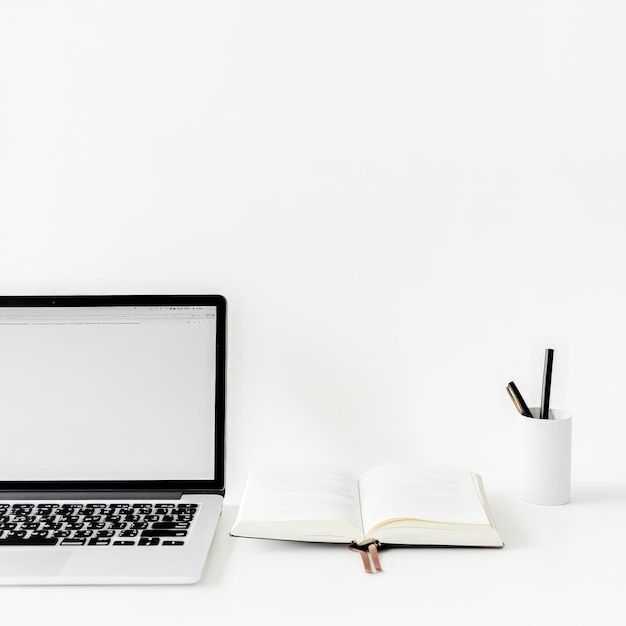 Laptop and Notebook on White Background with Copy Space