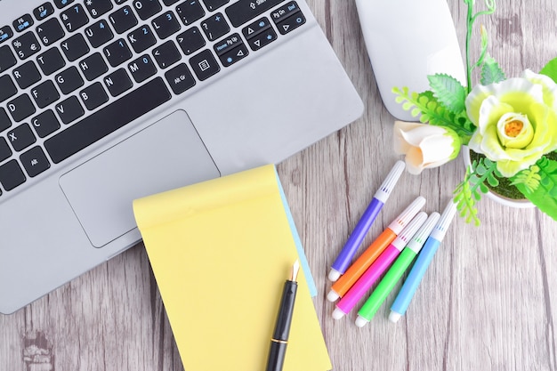 Laptop, notebook with magnifying glass on wooden table