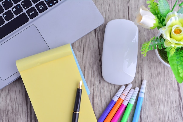 Laptop, notebook with magnifying glass on wooden table